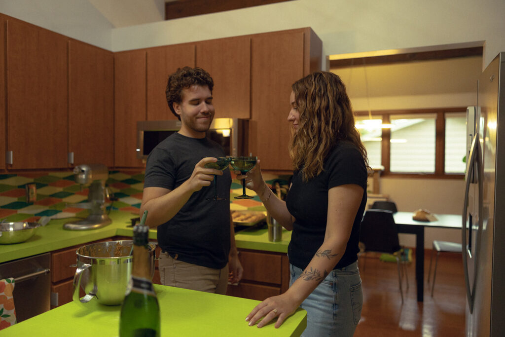 A Michigan couple cheers in celebration of their recent engagement during their Grand Rapids engagement photos in their MCM home 