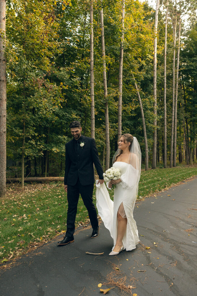 Newlyweds hold hands in their wedding attire following their ceremony at a venue for small weddings in MI