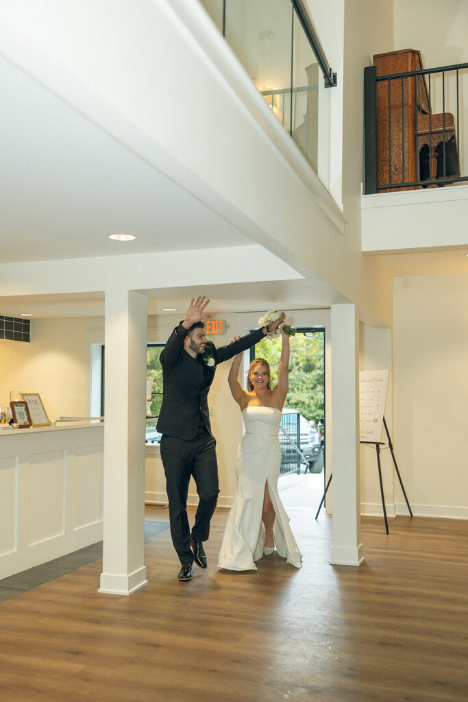 Newlyweds make a grand entrance to their reception in a photo taken by Michigan wedding photographer, Anika B Photography