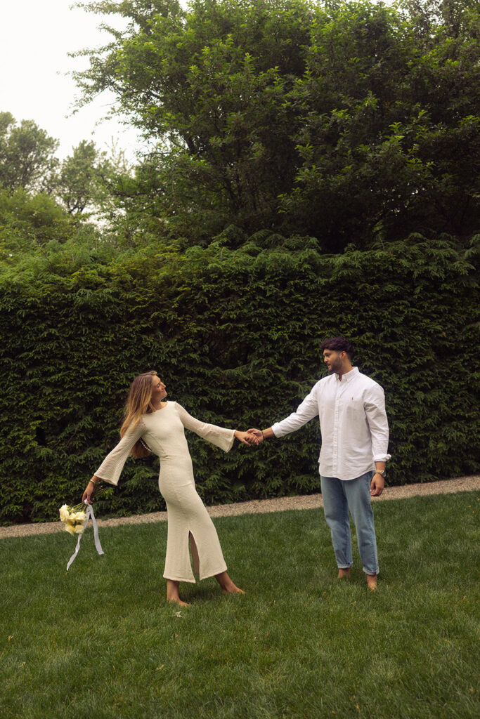 A Michigan couple holds hands during engagement photos taken at the henry ford wedding venue