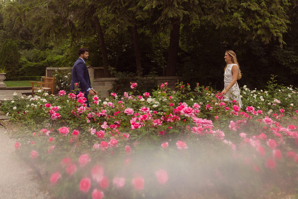 An engaged couple walks toward each other amongst the garden at the henry ford wedding venue 